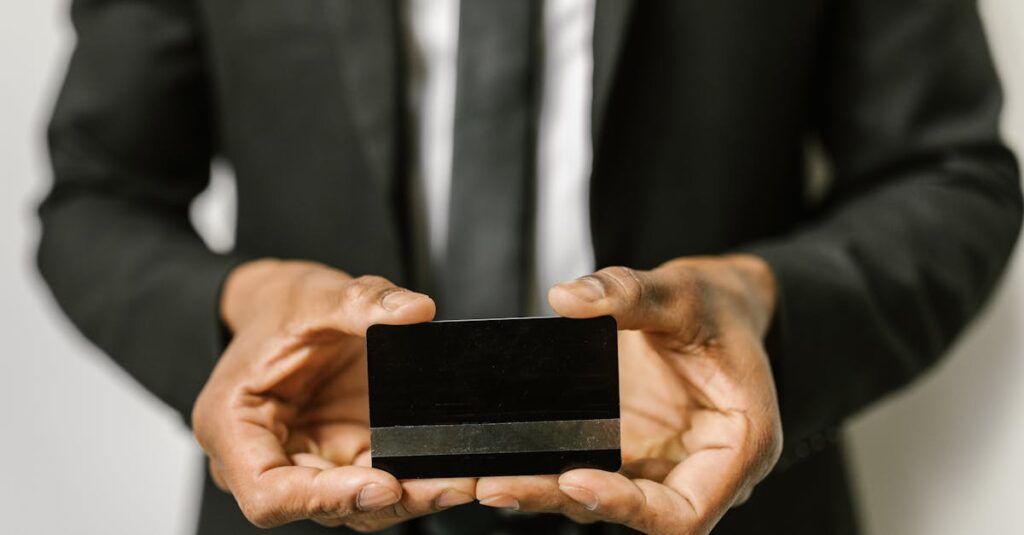 Close-up of a businessman holding a blank credit card with both hands, emphasizing finance.