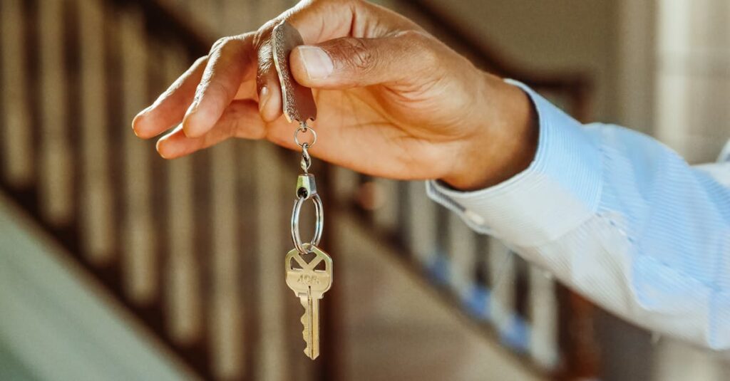 A close-up shot of a hand holding a house key, indicating new ownership or rental.