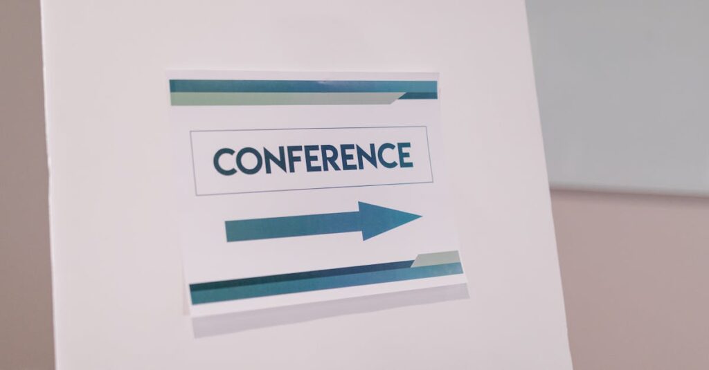 Close-up of a conference directional sign indoors, guiding participants.
