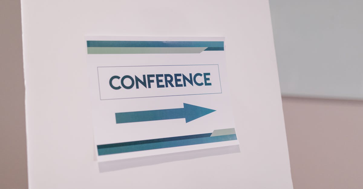 Close-up of a conference directional sign indoors, guiding participants.