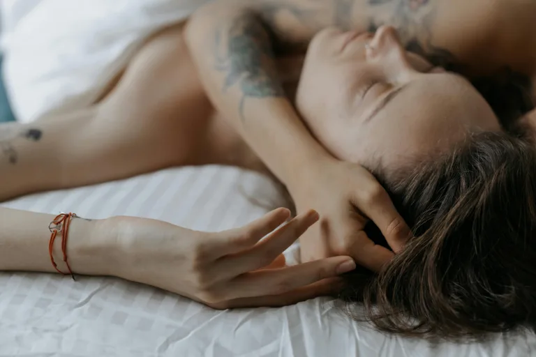 A serene moment of a couple embracing each other while resting in bed, expressing intimate and peaceful feelings.